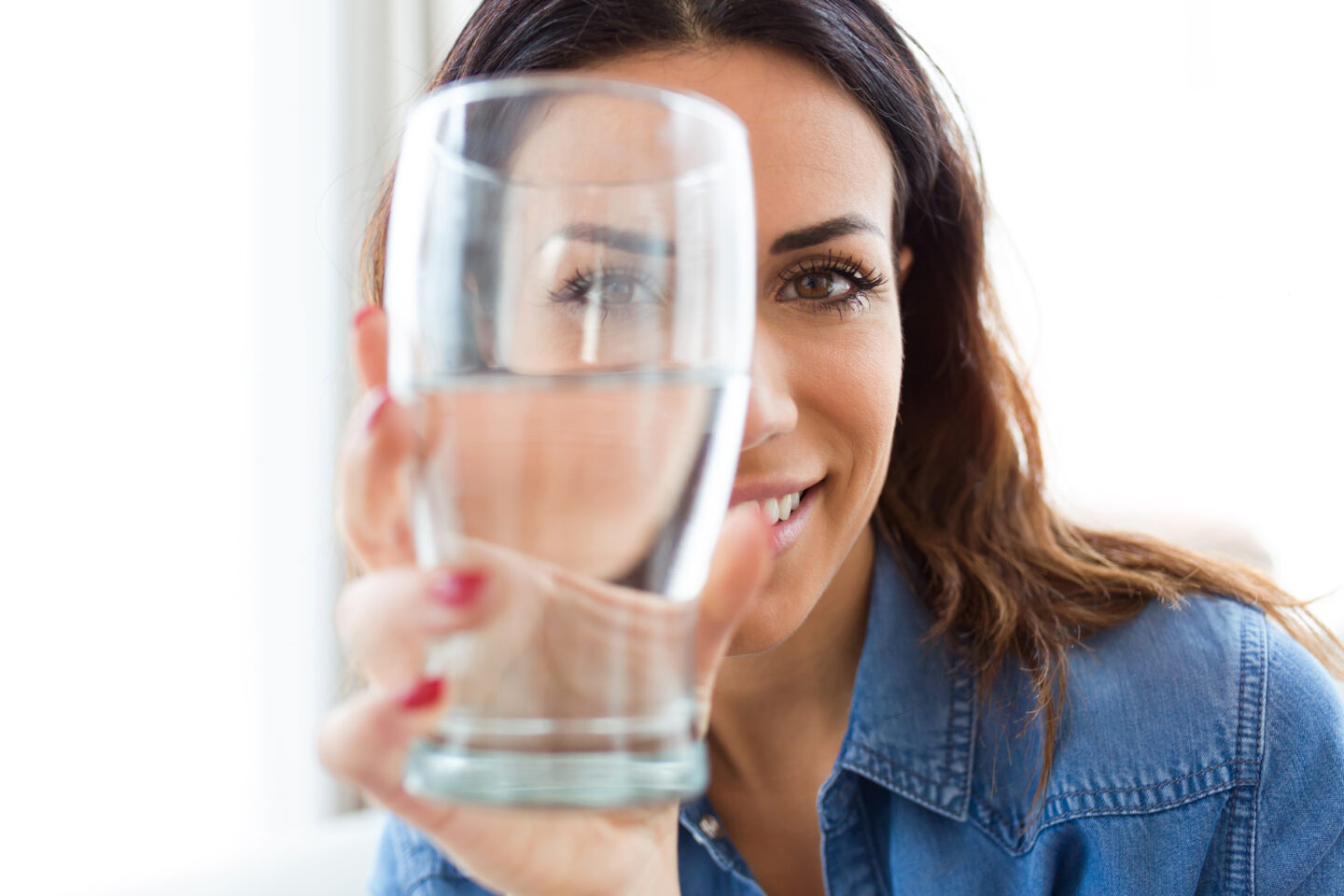 Frau hält ein großes Glas Wasser in den Händen