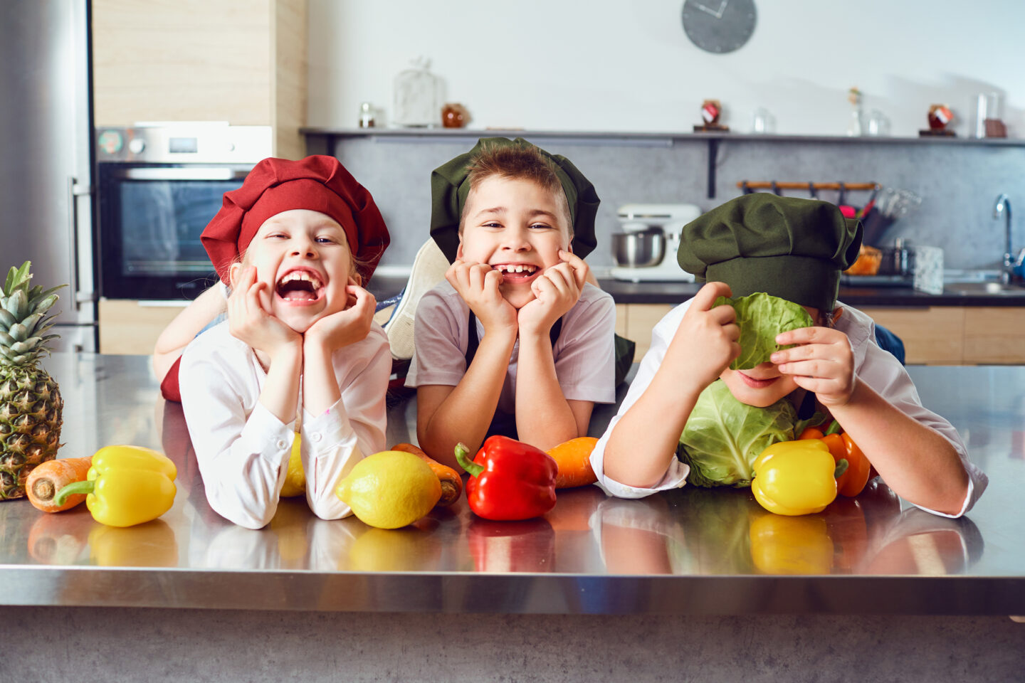 Drei Kinder in der Küche beim Vorbereiten eines vegetarischen Gerichtes