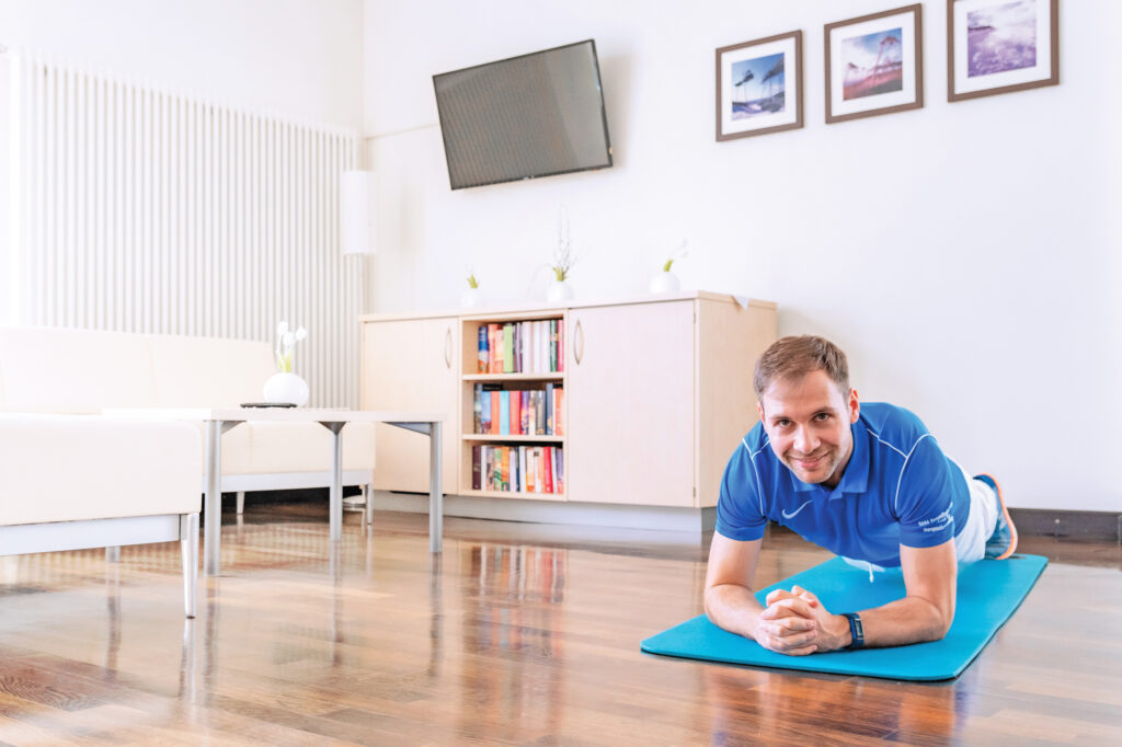 Mann beim Rückentraining zu Hause auf einer Fitnessmatte