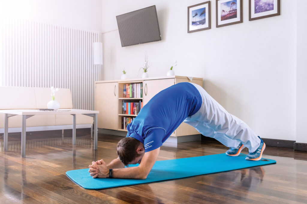 Mann beim Rückentraining zu Hause auf einer Fitnessmatte