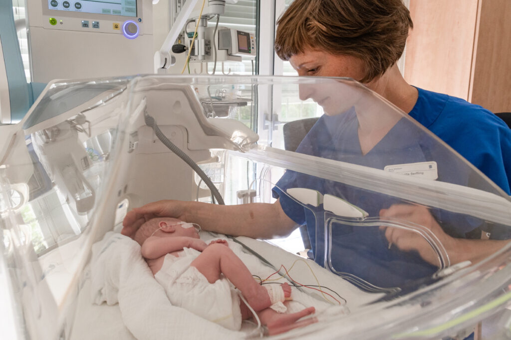 Kinderärztin mit krankem Neugeborenen auf Neonatologie