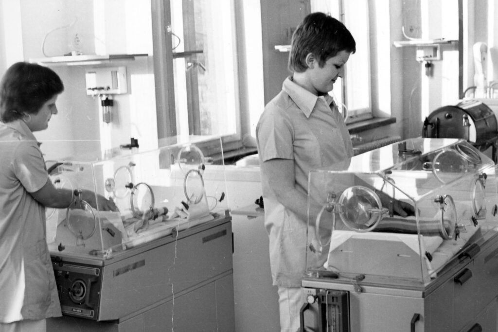 Hebamme und Kinderkrankenschwester der Geburtshilfe am Sana Klinikum Borna am Wärmebettchen für Neugeborene | Historische Aufnahme aus den 70er Jahren