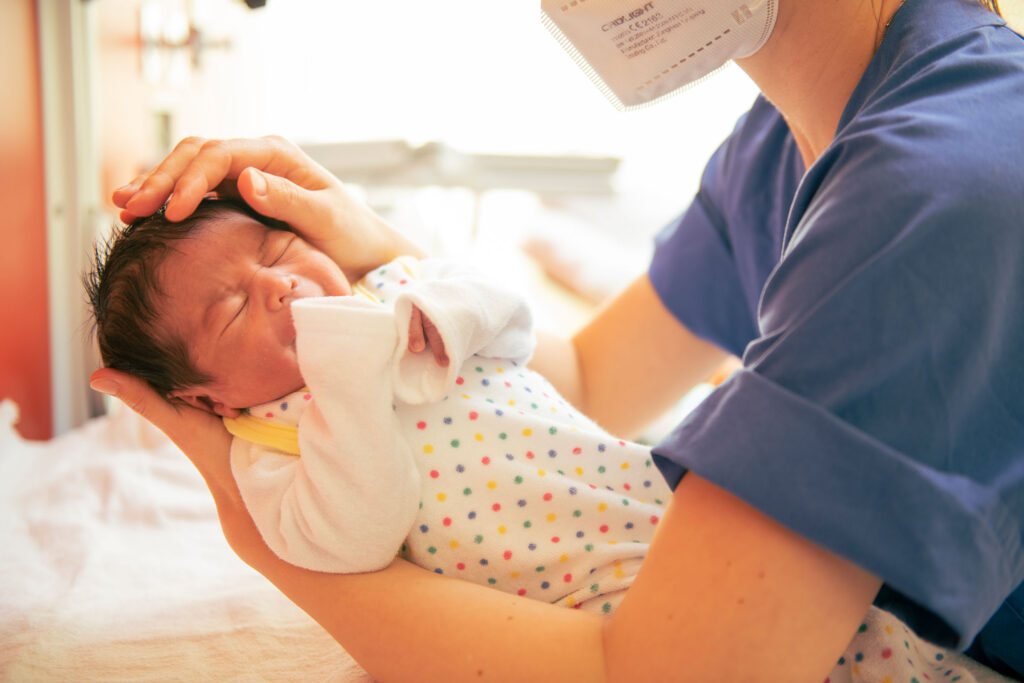 Kinderkrankenschwester untersucht Neugeborenes am Sana Klinikum Borna