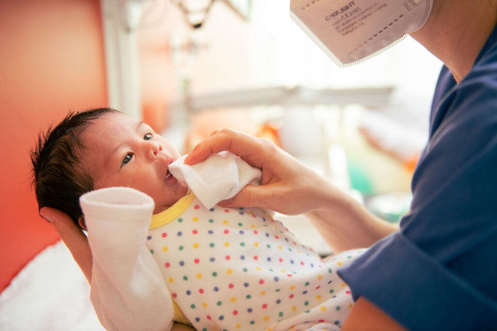 Medizinische Pflegerin kümmert sich um ein Neugeborenes auf der Neonatologie Station