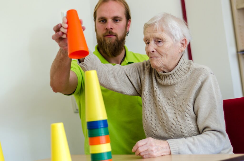 Patientin stapelt Turm in Ergotherapie