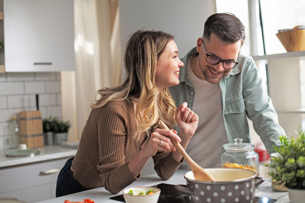 Junges Paar kocht zu Hause und achtet auf für Diabetiker geeignete Zutaten.