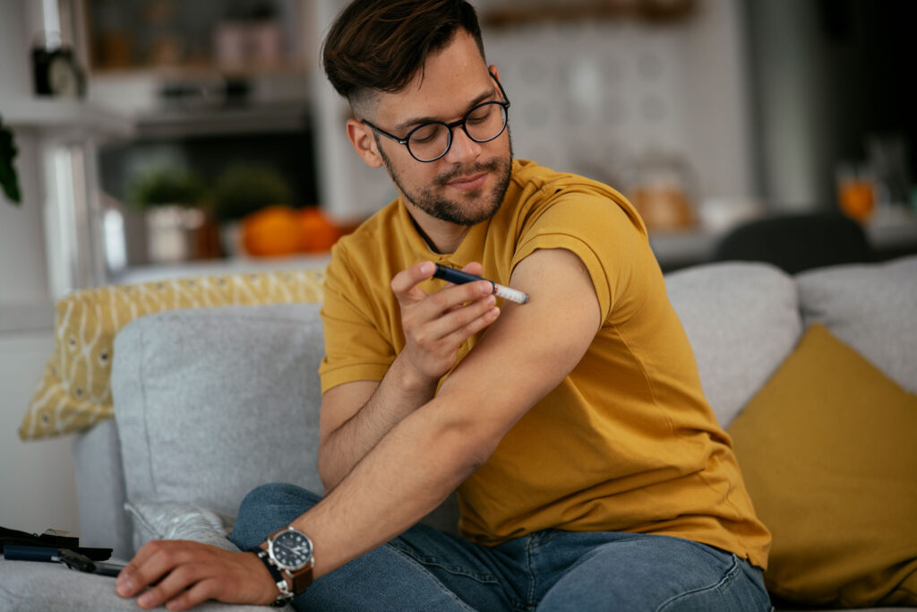 Junger Mann spritzt sich Insulin aufgrund seiner Diabeteserkrankung.