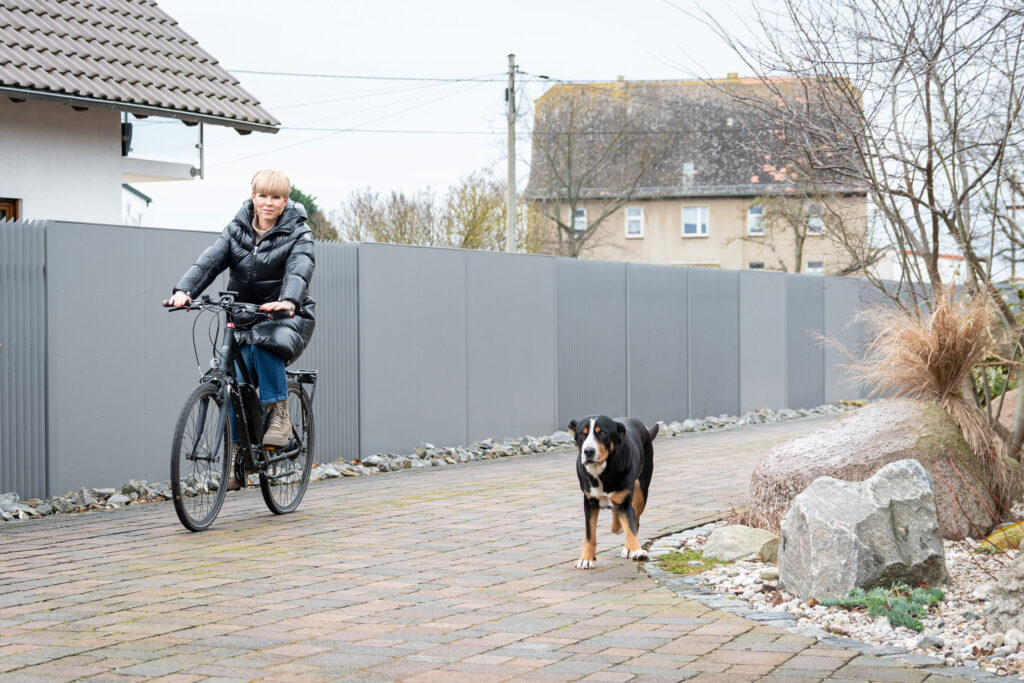 Patientin Jane Gonschior mit dem Fahrrad und in Begleitung ihres Hundes unterwegs.