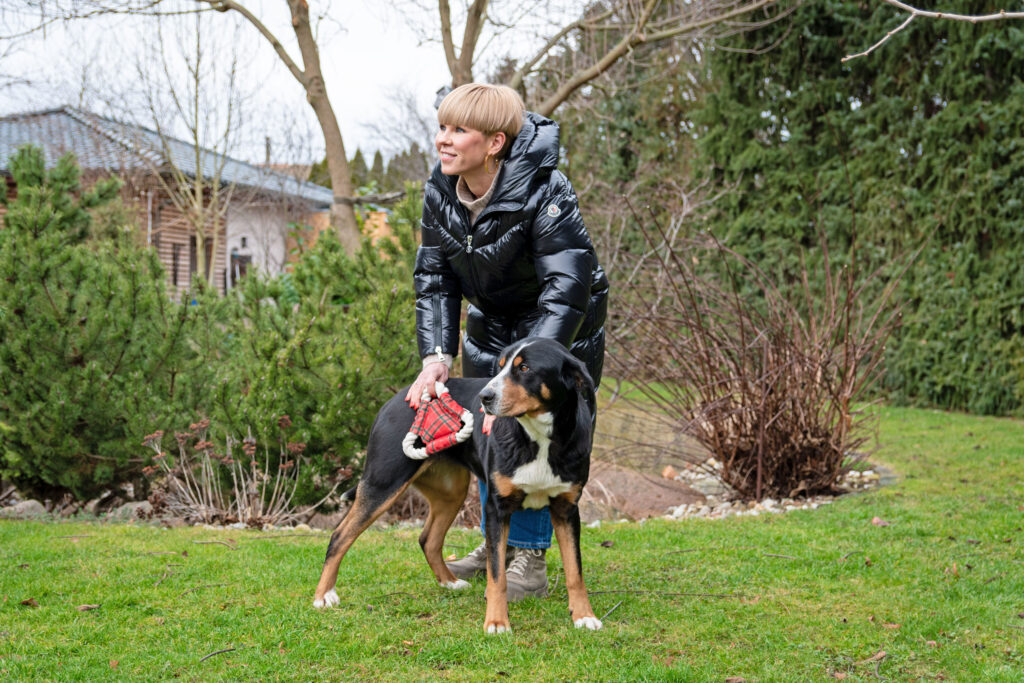 Patientin Jane Gonschior nach ihrer Wirbelsäulen-Operation im Garten mit ihrem Hund