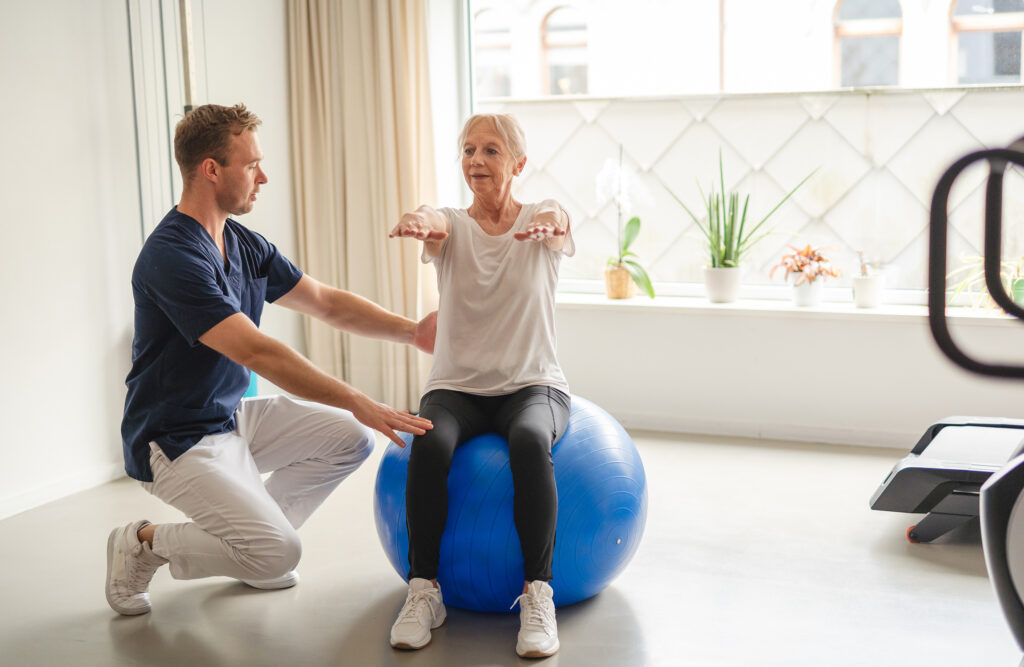 A young physiotherapist guiding an elderly woman through rehabilitation exercises, empowering her on the path to wellness